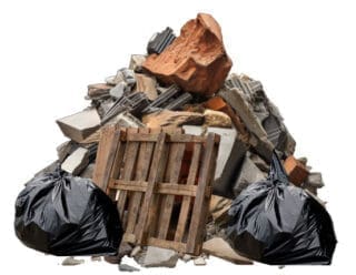 A pile of mixed construction waste including garbage bags, drywall, insulation and wood