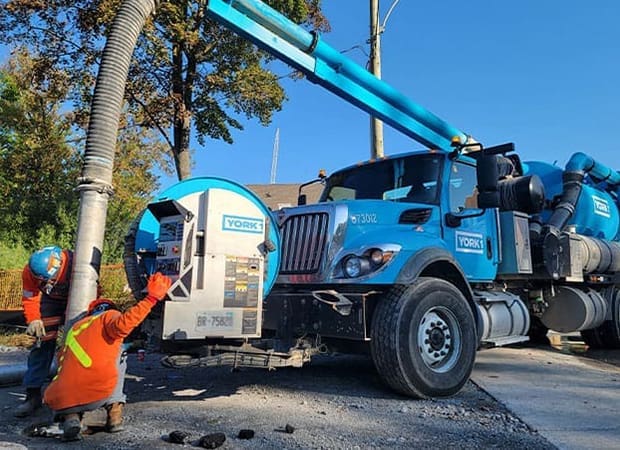 Blue Hydrovac Truck, Two Workers in full PPE